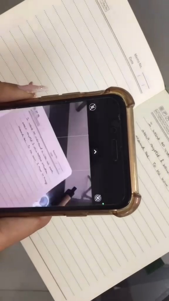 An iPhone photographing a handwritten journal page